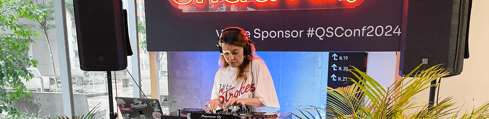 DJ ambientando el evento con una cabina brandeada por sponsors.