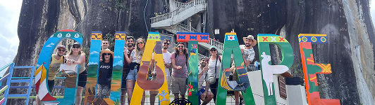 Networking de la comunidad en Colombia, frente a mural en Guatapé.