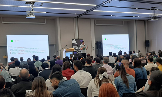 QSConf en Colombia: sala plenaria con asistentes y pantallas.